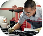 Toyota technician inspecting an engine